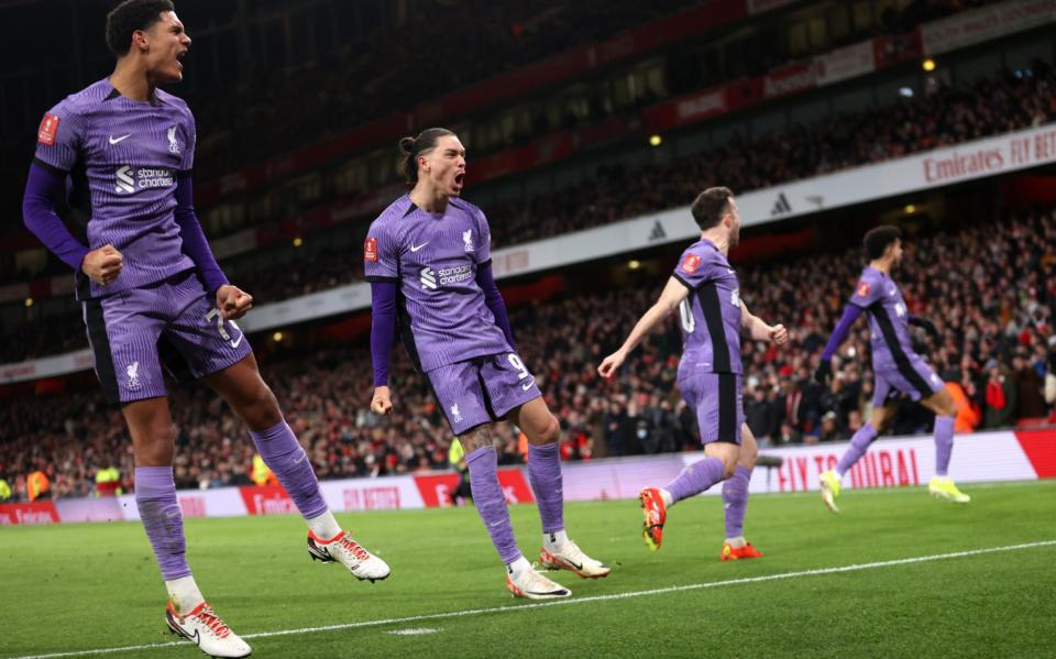 Liverpool players celebrate in front of their fans after going ahead at Arsenal