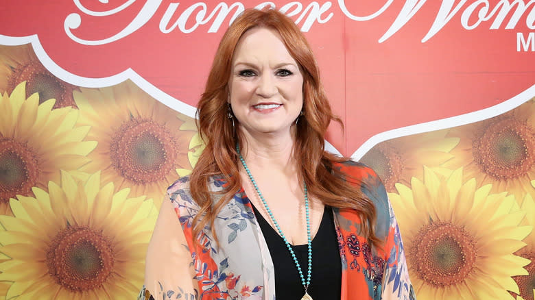 Ree Drummond posing in front of Pioneer Woman sign