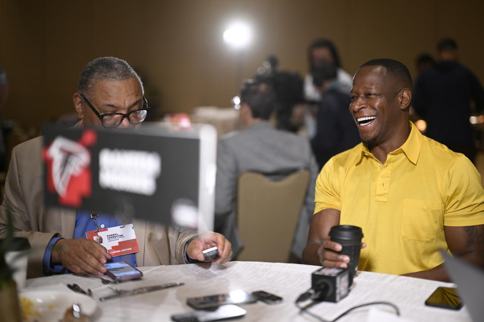 Atlanta Falcons head coach Raheem Morris, right, talks with reporters during an NFC coaches availability at the NFL owners meetings, Tuesday, March 26, 2024, in Orlando, Fla. (AP Photo/Phelan M. Ebenhack)