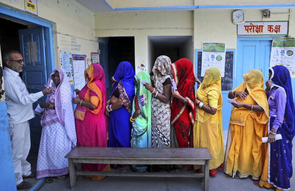 FILE - In this May 6, 2019 file photo, Indian women stand in a queue to cast their vote in Neemrana, in the northern Indian state of Rajasthan. The final phase of India’s marathon general election will be held on Sunday, May 19. The first of the election’s seven staggered phases was held on April 11. Vote counting is scheduled to start on May 23. India has 900 million eligible voters. (AP Photo/Manish Swarup, File)