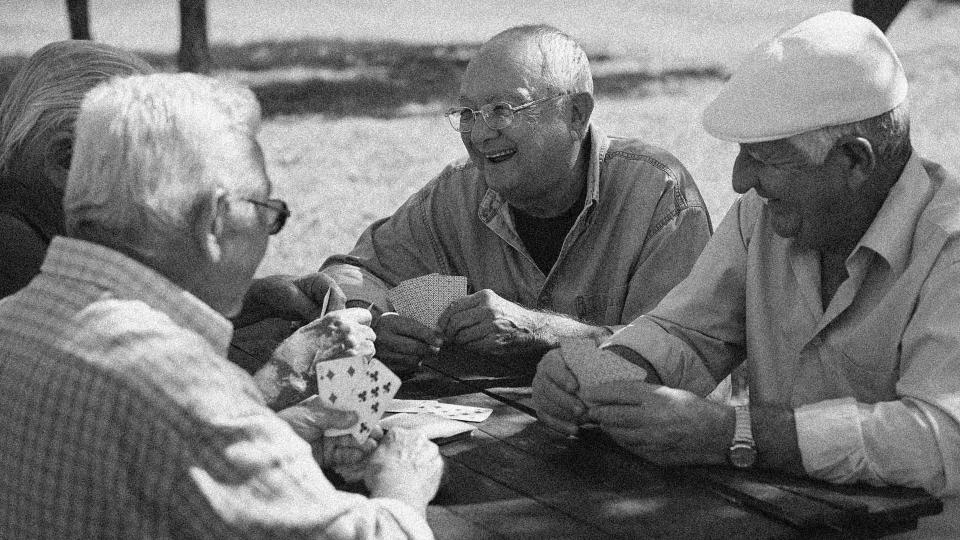 retired men playing cards together