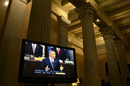 U.S. President Barack Obama is seen on a television screen placed in the hallway outside the U.S. House of Representatives chamber, for journalists traveling with the president to watch his final State of the Union address to a joint session of Congress in Washington January 12, 2016. REUTERS/James Lawler Duggan -