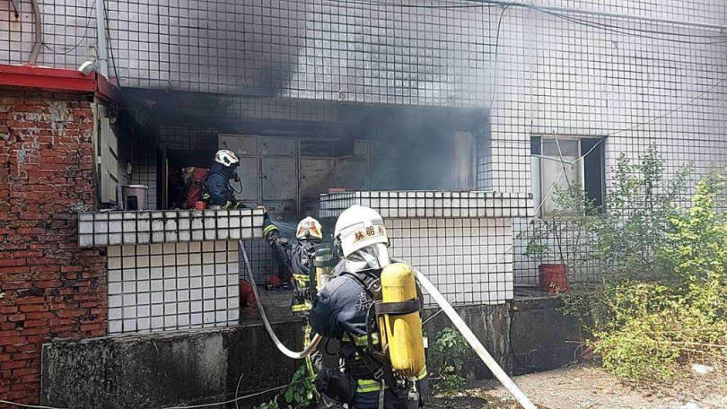 嘉義市消防隊員在大樓後陽台灌救發火燒爆的金爐。（圖／讀者提供）