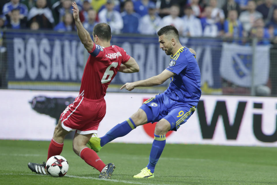 Bosnia's Vedad Ibisevic, right, takes a shot to score a goal, challenged by Gibraltar's Roy Chipolina, during their World Cup Group H qualifying match at the Bilino Polje Stadium in Zenica on Saturday, March 25, 2017. (AP Photo/Amel Emric)