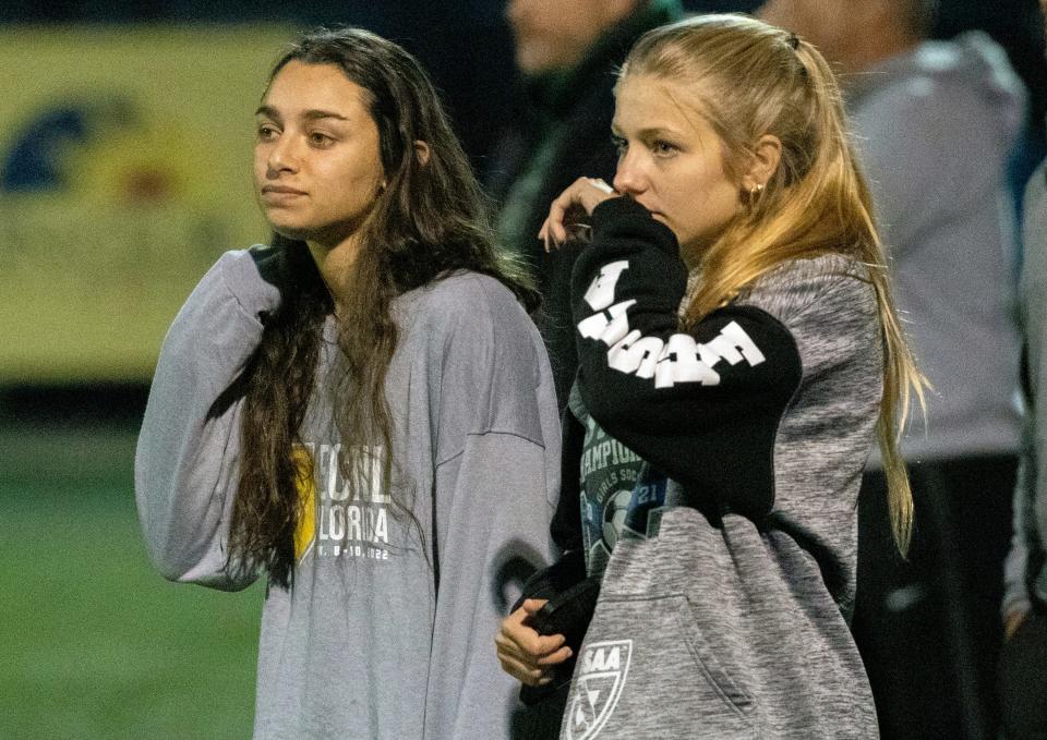 Injured Vikings Maddie Lopez and Carly Sabat watch the final minute of the match as Lakeland Christian defeated McKeel, 2-0.