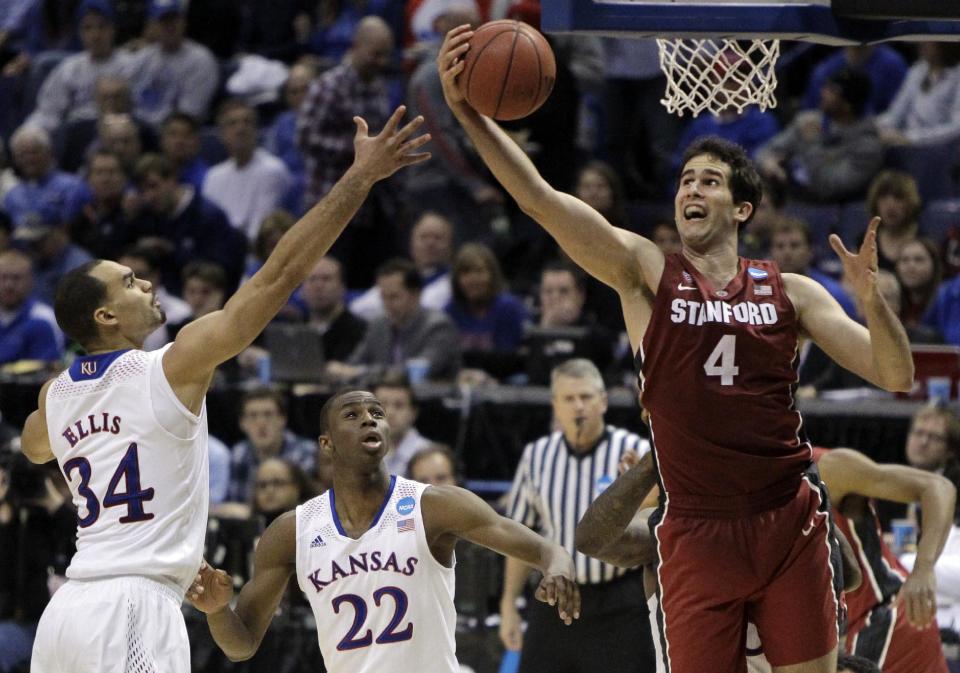 Stanford's Stefan Nastic, right, heads to the basket as Kansas' Perry Ellis, left, and Andrew Wiggins watch during the second half of a third-round game of the NCAA college basketball tournament Sunday, March 23, 2014, in St. Louis. Stanford won 60-57. (AP Photo/Jeff Roberson)