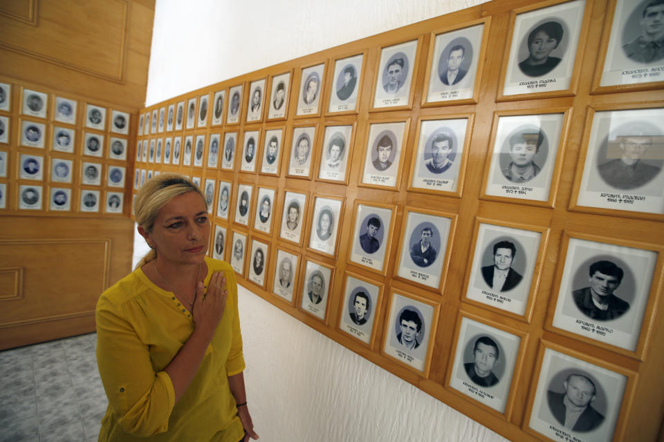 A Bosnian Serb woman Radojka Filipovic walks through the memorial room for Bosnian Serb victims killed by Bosnian Muslim soldiers in Bratunac, Bosnia, Tuesday, Aug. 14, 2018. President of Bosnian Serbs Milorad Dodik has downplayed the massacre of some 8,000 Bosnian Muslims in Srebrenica during the war in 1995 and called for the reopening of an investigation into the worst carnage in Europe since World War II. (AP Photo/Darko Vojinovic)