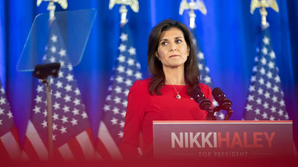 nikki haley standing at a podium with her name on it and looking out into the audience