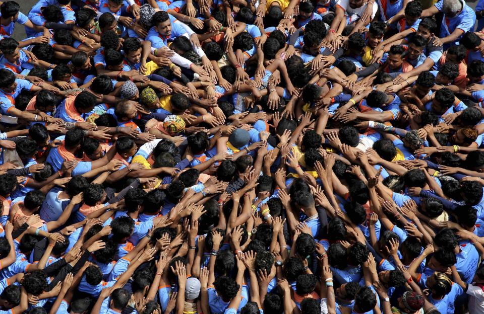 <p>Indische Jugendliche formen anlässlich des Janmashtami-Festes eine zeremonielle Pyramide. Mit dem Fest feiern die Hindus die Geburt des Gottes Krishna. Ein zeremonielles Zerschlagen eines Topfes mit Quark erinnert daran, dass Krishna während seiner Kindheit Butter stehlen musste. (AP Photo/Rafiq Maqbool) </p>