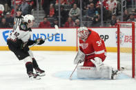 Arizona Coyotes center Logan Cooley (92) schores on Detroit Red Wings goaltender Alex Lyon (34) during the first period of an NHL hockey game, Thursday, March 14, 2024, in Detroit. (AP Photo/Carlos Osorio)