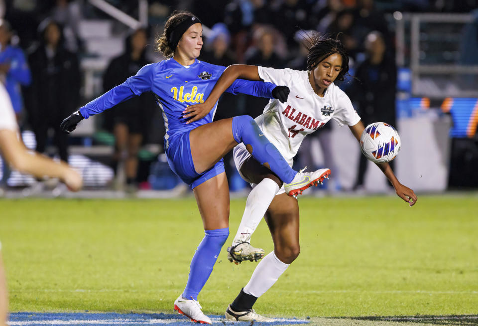 UCLA's Ally Lemos, left, and Alabama's Gianna Paul compete for the ball during the first half of an NCAA women's soccer tournament semifinal in Cary, N.C., Friday, Dec. 2, 2022. (AP Photo/Ben McKeown)