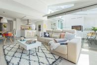 <p>La sala de estar, equipada con sofá con cojines de Normann Copenhagen, Boho Deco Chick, Hay y Fine Little Day y mesa de centro, se delimita con una alfombra de HK Living.</p>