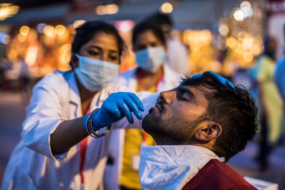 A health worker collects a nasal swab sample from a Hindu devotee to test for the Covid-19 coronavirus during the ongoing religious Kumbh Mela festival in Haridwar on April 12, 2021. (Photo by Xavier GALIANA / AFP) (Photo by XAVIER GALIANA/AFP via Getty Images)