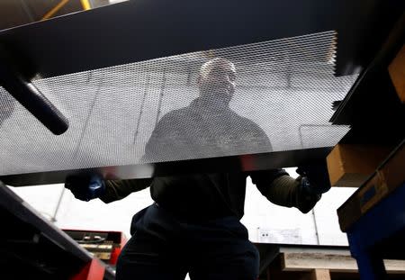 A worker at perforating company Bion handles a piece of perforated metal at the factory in Reading, Britain September 22, 2016. REUTERS/Peter Nicholls