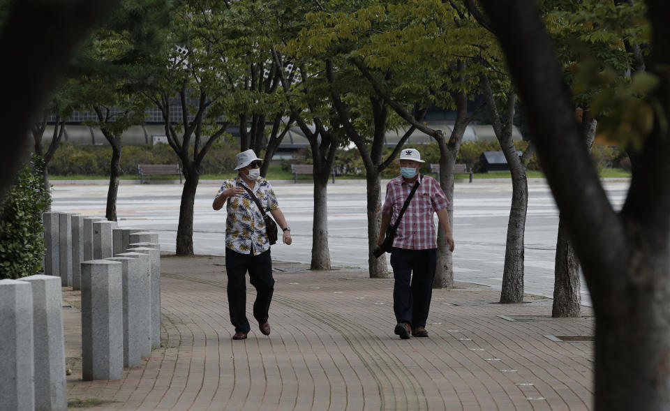 Visitors wearing face masks as a precaution against the coronavirus walk while maintaining social distancing in Seoul, South Korea, Friday, Sept. 11, 2020. (AP Photo/Lee Jin-man)