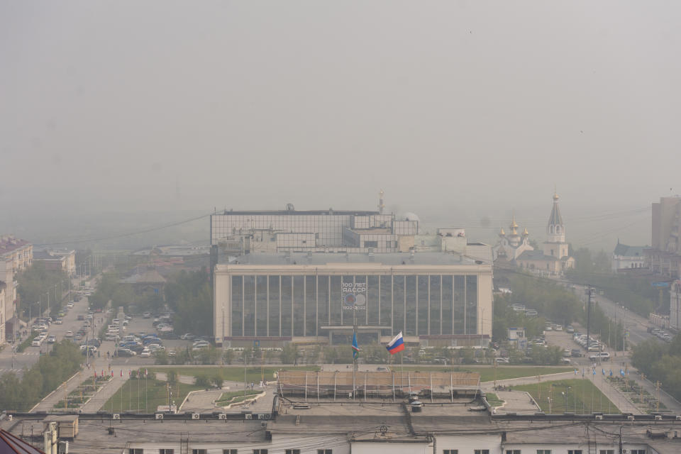 FILE - In this Monday, July 19, 2021 file photo, smoke from a forest fire covers Yakustk, the capital of the republic of Sakha also known as Yakutia, Russia Far East. Each year, thousands of wildfires engulf wide swathes of Russia, destroying forests and shrouding broad territories in acrid smoke. This summer has seen particularly massive fires in Yakutia in northeastern Siberia following unprecedented heat. (AP Photo/Yevgeny Sofroneyev, File)