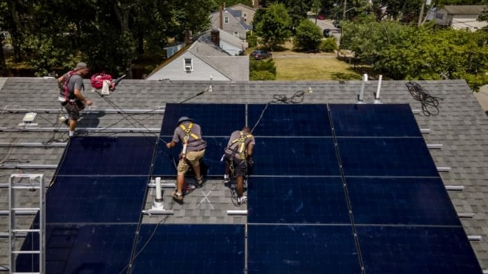 Employees of NY State Solar, a residential and commercial photovoltaic systems company, install an array of solar panels on a roof Thursday in the Long Island hamlet of Massapequa, N.Y. (Photo: John Minchillo/AP, File)