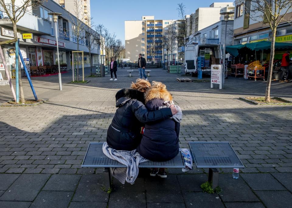 Two woman mourn near a kiosk in Hanau, Germany Friday, Feb. 21, 2020 two days after a 43-year-old German man shot and killed several people at several locations in a Frankfurt suburb on Wednesday, Feb. 19, 2020. (AP Photo/Michael Probst)