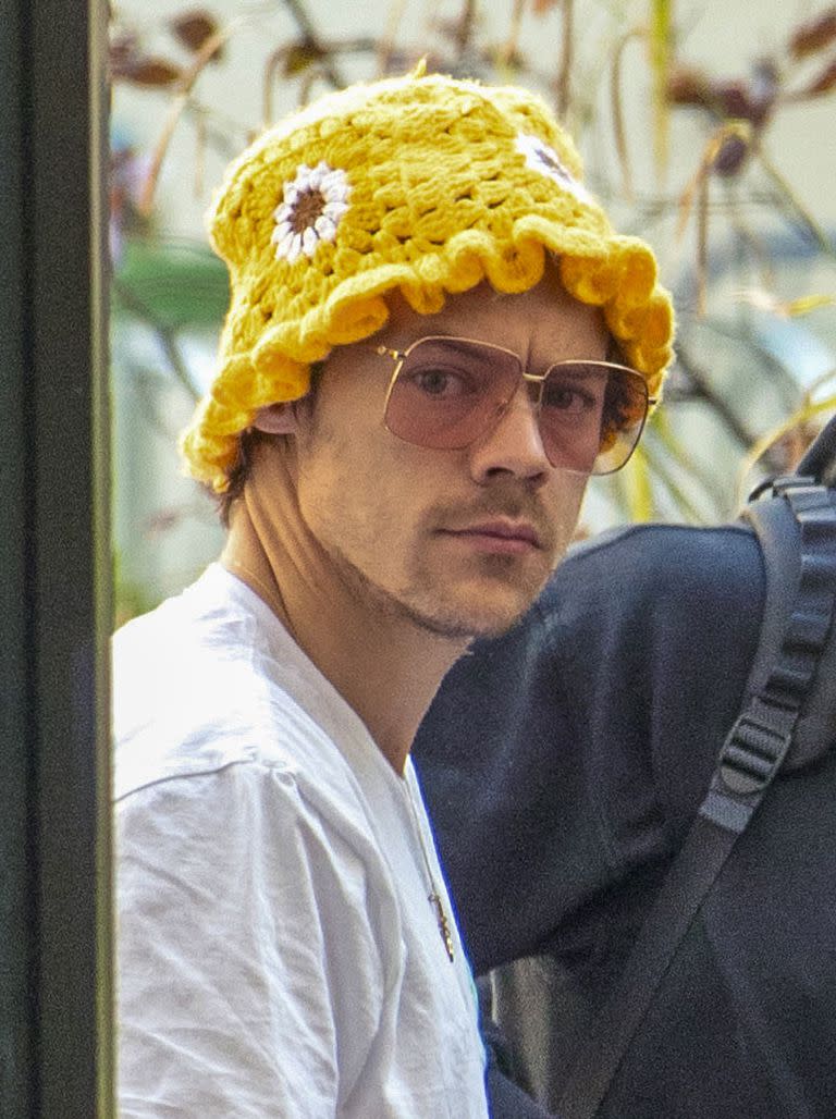 El cantante británico Harry Styles, en su arribo a la capital alemana, luciendo un divertido sombrero de crochet amarillo con flores