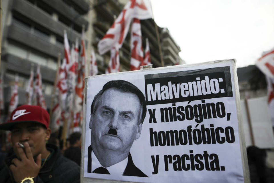 A man holds a sign that reads in Spanish "Not Welcomed for being a misogynist, homophobe and a racist" during a protest against the visit of Brazil's President Jair Bolsonaro to Argentina, in front of the Brazilian embassy in Buenos Aires, Thursday, June 6, 2019.(AP Photo/Natacha Pisarenko)