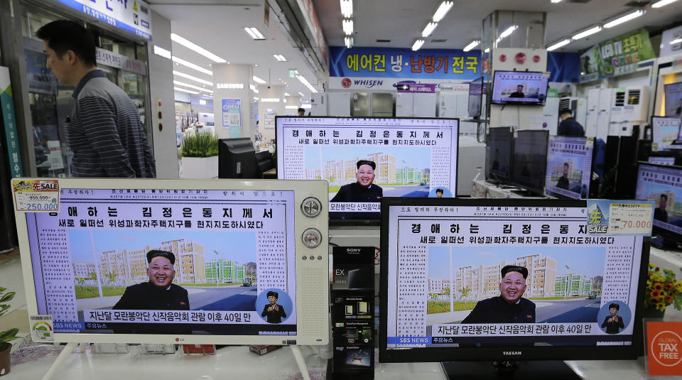 FILE - A man walks past TV monitors displaying a news program at an electronic shop in Seoul, South Korea, on Oct. 14, 2014, showing a North Korean newspaper with a photo of North Korean leader Kim Jong Un smiling, reportedly during his first public appearance in five weeks in Pyongyang, North Korea. The writing reads, "Honorable Kim Jong Un." South Korea plans to lift its decades-long ban on public access to North Korean television, newspapers and other media as part of its efforts to promote mutual understanding between the rivals, officials said Friday, July 22, 2022, despite animosities over the North's recent missile tests. (AP Photo/Ahn Young-joon, File)
