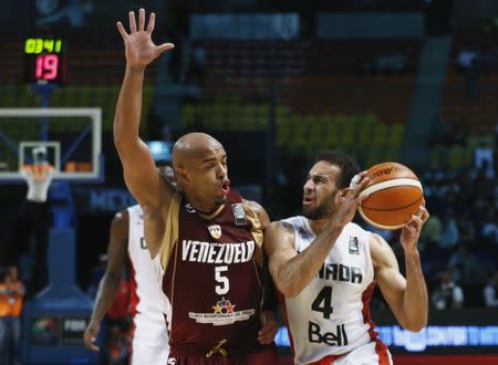 Canada's Philip Scrubb (4) controls the ball against Venezuela's Gregory Vargas (5) during their 2015 FIBA Americas Championship semi-final basketball game, at the Sports Palace in Mexico City September 11, 2015. REUTERS/Henry Romero