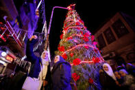 People take a selfie in front of a Christmas tree in the Qasaa district, Damascus, Syria December 14, 2018. Picture taken December 14, 2018. REUTERS/Omar Sanadiki