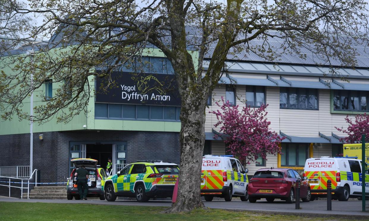 <span>Emergency services vehicles outside Ysgol Dyffryn Aman in Ammanford, Wales.</span><span>Photograph: Wales News Service</span>