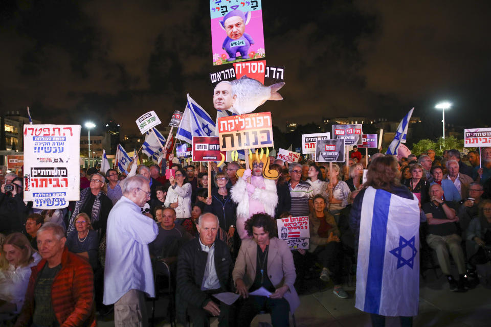 Protesters hold banners during a rally calling for the resignation of Israel's Prime Minister Benjamin Netanyahu, in Tel Aviv, Israel, Saturday, Nov. 30, 2019. (AP Photo/Oded Balilty)