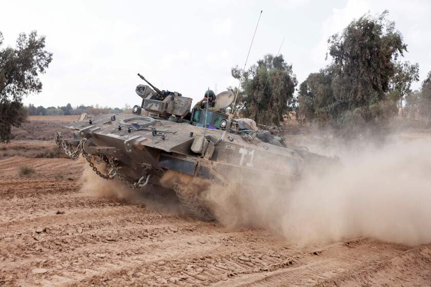 Israeli troops advance near the border with the Gaza Strip on November 14, 2023, amid ongoing battles between Israel and the Palestinian group Hamas. (Photo by Menahem KAHANA / AFP) (Photo by MENAHEM KAHANA/AFP via Getty Images)