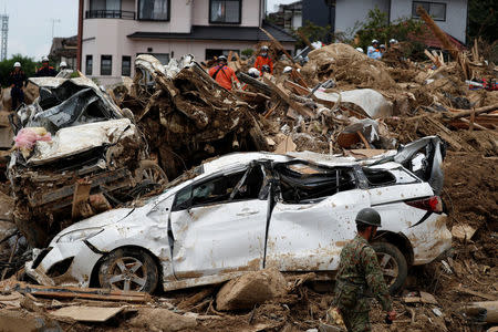 Rescue workers conduct search and rescue operations at a landslide site caused by heavy rain in Kumano Town, Hiroshima Prefecture, western Japan, July 11, 2018. REUTERS/Issei Kato