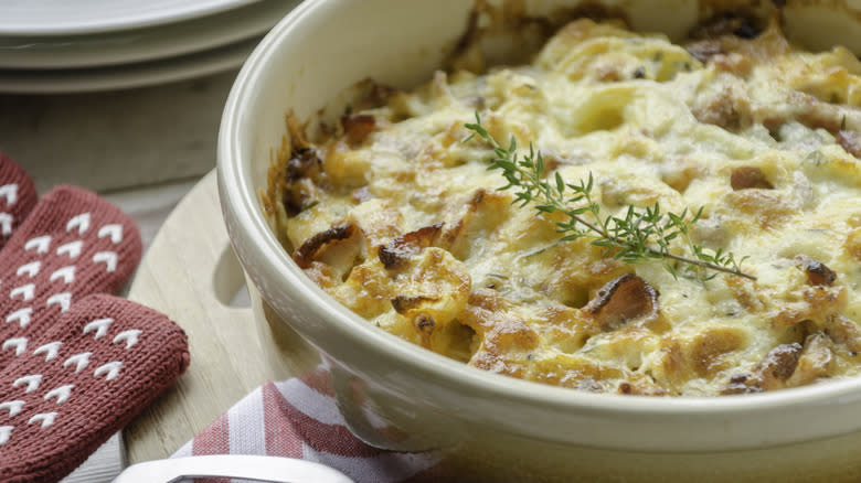 chicken bacon casserole in white dish on wooden cutting board