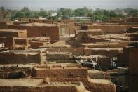 A boy walks amid mud brick houses in the old city of Agadez, September 24, 2013. REUTERS/Joe Penney