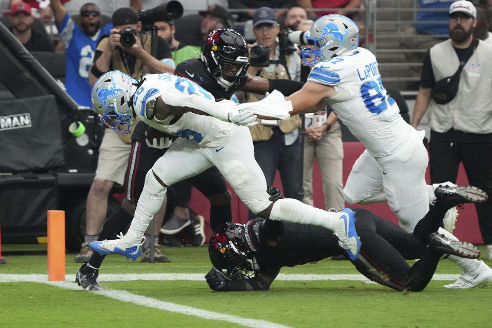 Detroit Lions running back Jahmyr Gibbs (26) scores a touchdown on a run after receiving a lateral from wide receiver Amon-Ra St. Brown during the first half of an NFL football game against the Arizona Cardinals Sunday, Sept. 22, 2024, in Glendale, Ariz. (AP Photo/Rick Scuteri)