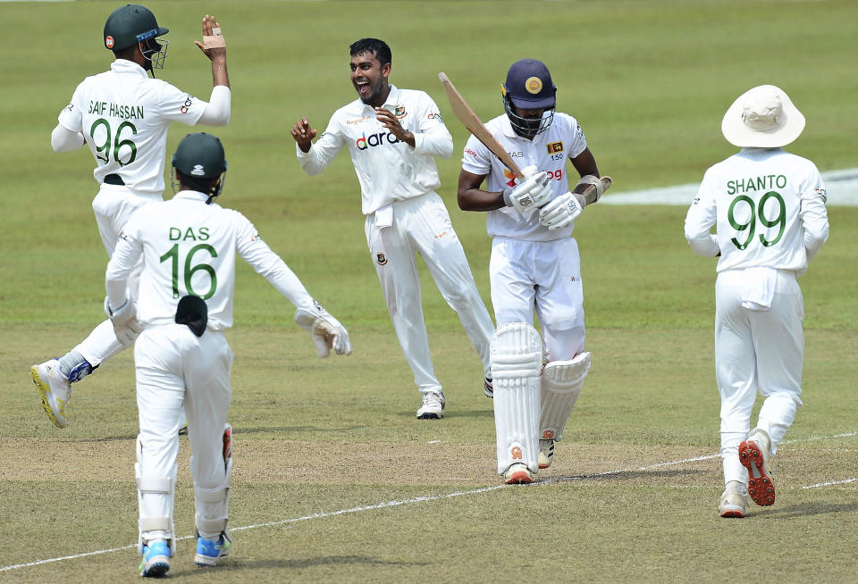 Bangladesh's Mehidy Hasan, center, celebrates with teammates the dismissal of Sri Lanka's Oshada Fernando, second right, during the second day of the second test cricket match between Sri Lanka and Bangladesh in Pallekele, Sri Lanka, Friday, April 30, 2021. ( AP Photo/Sameera Peiris)