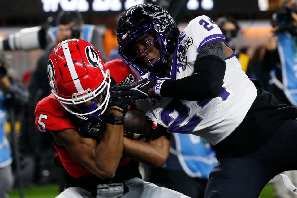 Georgia wide receiver Adonai Mitchell catches a touchdown pass while being defended by TCU cornerback Josh Newton during last season's CFP championship game. Mitchell has transferred to Texas.