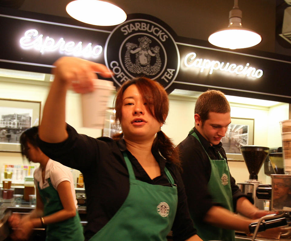 Employees prepare beverages in the first Starbucks coffee shop in Seattle, 30 September 2006. AFP PHOTO/GABRIEL BOUYS 