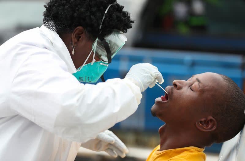 A member of medical staff swabs the mouth of a resident as she is testing for a virus