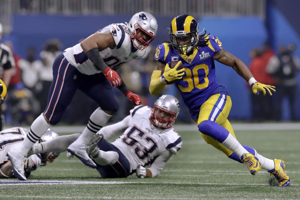 Los Angeles Rams' Todd Gurley II (30) runs from New England Patriots' Trey Flowers, left, and Kyle Van Noy (53) during the second half of the NFL Super Bowl 53 football game Sunday, Feb. 3, 2019, in Atlanta. The play was nullified by a Rams holding penalty. (AP Photo/Carolyn Kaster)