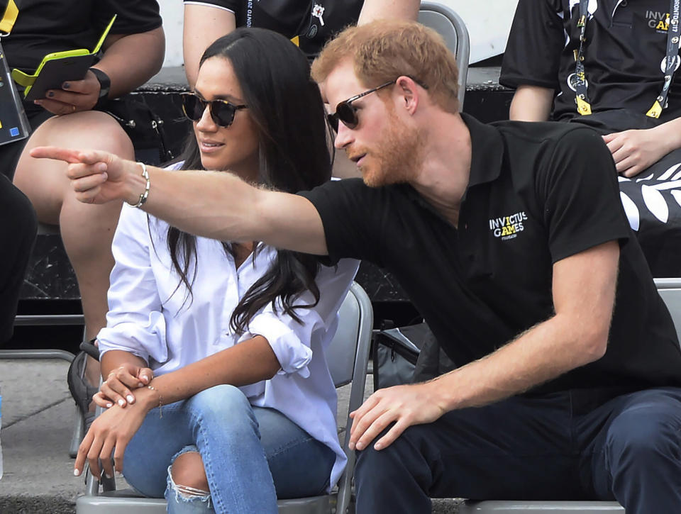 FILE - In this Monday, Sept. 25, 2017 file photo Prince Harry and his then girlfriend Meghan Markle attend a wheelchair tennis event at the Invictus Games in Toronto. In a stunning declaration, Britain's Prince Harry and his wife, Meghan, said they are planning "to step back" as senior members of the royal family and "work to become financially independent." A statement issued by the couple Wednesday, Jan. 8, 2020 also said they intend to "balance" their time between the U.K. and North America. (Nathan Denette/The Canadian Press via AP, FILE)