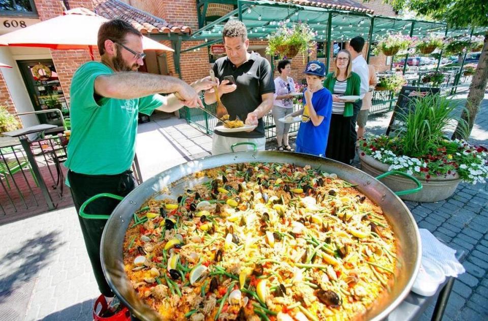 Tony Eiguren serves from a gigantic 100 person paella-filled pan prepared for lunch at The Basque Market in this file photo from July 1, 2015.