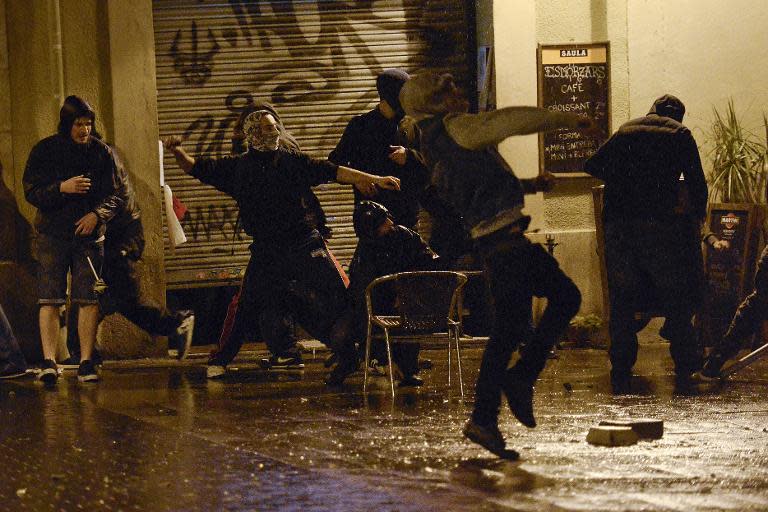 Protestors throw projectiles in Barcelona on May 28, 2014 on the third night of clashes following evictions of activists