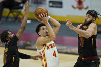 Atlanta Hawks' Skylar Mays (4) drives to the basket between Cleveland Cavaliers' Darius Garland (10) and JaVale McGee (6) in the second half of an NBA basketball game, Tuesday, Feb. 23, 2021, in Cleveland. (AP Photo/Tony Dejak)