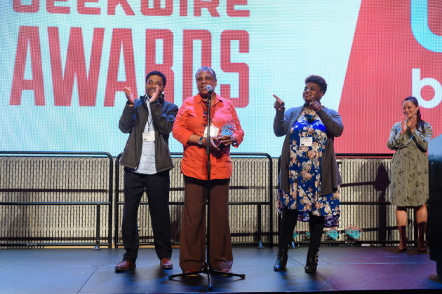 Trish Millines Dziko, co-founder and executive director of Technology Access Foundation, accepts the Geeks Give Back award as TAF’s Tyrone Cunningham and Shaunte Nance-Johnson look on. (GeekWire Photo / Kevin Lisota) <a href="https://www.geekwire.com/2018/revealed-winners-of-the-2018-geekwire-awards/" rel="nofollow noopener" target="_blank" data-ylk="slk:Read the story.;elm:context_link;itc:0;sec:content-canvas" class="link "><strong>Read the story.</strong></a>