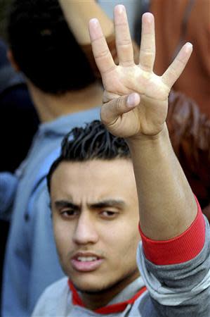 A Cairo University student supporting the Muslim Brotherhood and deposed President Mohamed Mursi, gestures a "Rabaa" sign and shouts slogans at the university's campus in Cairo December 29, 2013. REUTERS/Stringer