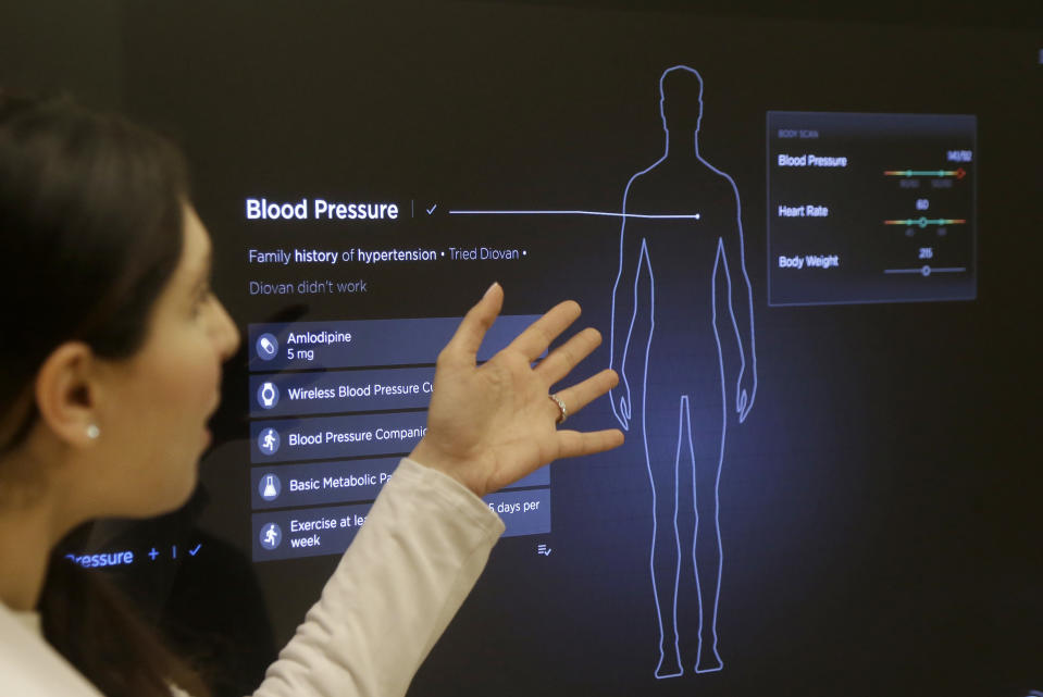 In this Jan. 10, 2017 photo, Dr. Aaliya Yaqub points to a large monitor while giving a demonstration of medical checkup at a Forward medical office in San Francisco. After a relative suffered a heart attack a few years ago, Silicon Valley entrepreneur Adrian Aoun got an up-close look at a health-care system that he diagnosed as an inefficient and outdated mess. Now, Aoun is ready to prescribe his remedy. It's called Forward, a health-management service that charges a $149 per month, roughly $1,800 a year, to tend to all of its patients' primary-care needs. (AP Photo/Jeff Chiu)