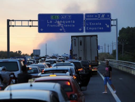 A traffic jam is seen as a wildfire destroys the forest in Ller near La Junquera (Girona), close to the Spanish-French border. The wildfire whipped up by strong winds left three people dead Sunday and about 100 people injured and forced thousands of residents to remain indoors, officials said