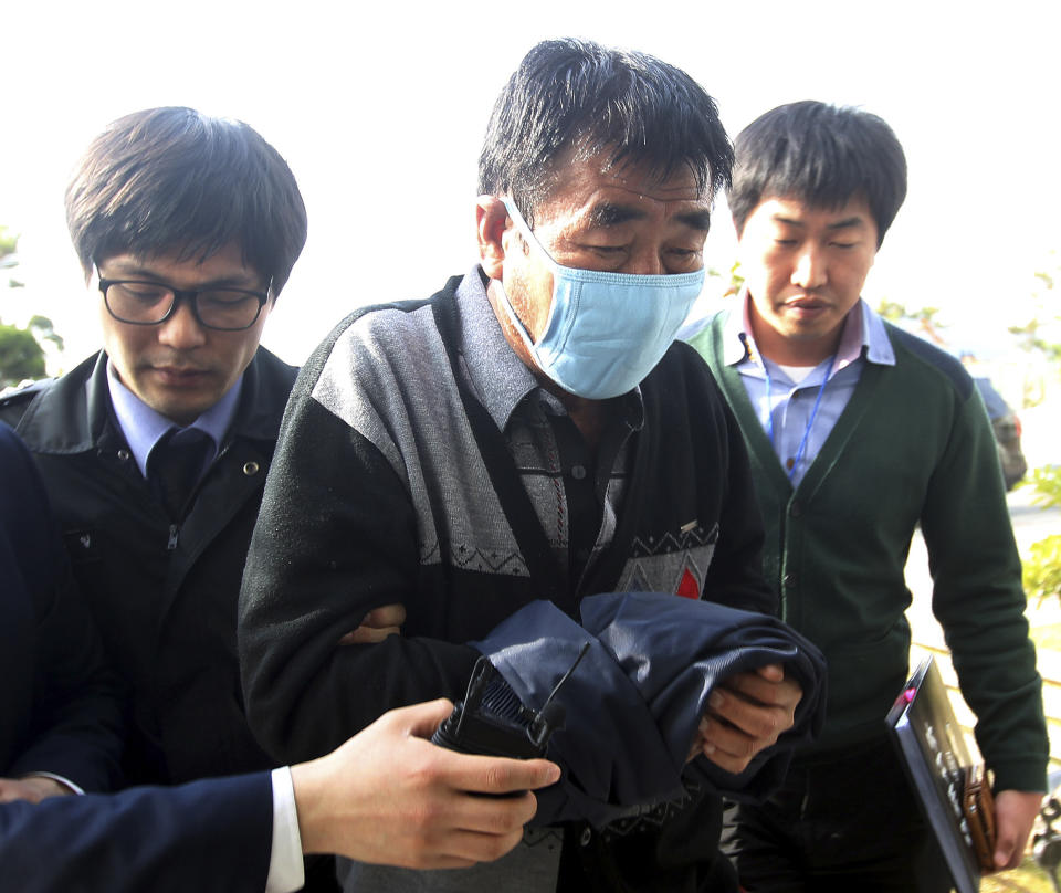 Lee Joon-seok (centro), capitán del ferri que se hundió en la costa de Corea del Sur, a su llegada a los cuarteles de la policía en Mokpo, al sur de Seúl, el 19 de abril de 2013. (Foto de AP/Yonhap, archivo) Prohibido su uso en Corea del sur