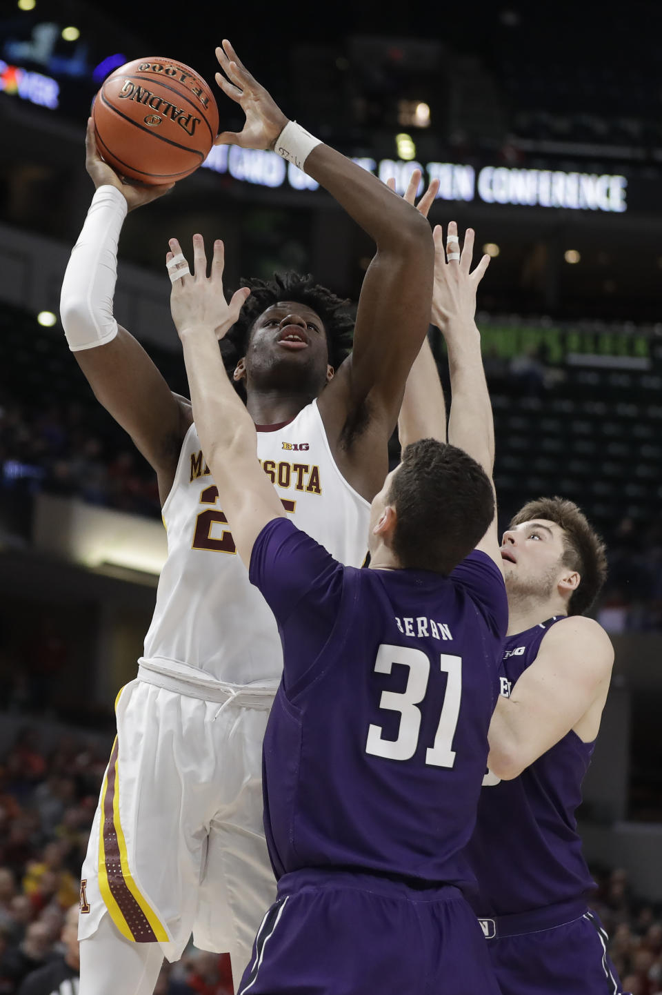 Minnesota's Daniel Oturu (25) puts up a shot over Northwestern's Robbie Beran (31) during the first half of an NCAA college basketball game at the Big Ten Conference tournament, Wednesday, March 11, 2020, in Indianapolis. (AP Photo/Darron Cummings)