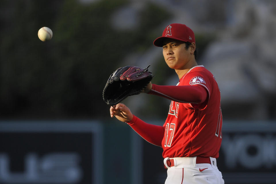 CORRECTS POSITION TO STARTING PITCHER INSTEAD OF DESIGNATED HITTER - Los Angeles Angels starting pitcher Shohei Ohtani takes the ball back from the catcher during the first inning of a baseball game against the Tampa Bay Rays, Wednesday, May 5, 2021, in Anaheim, Calif. (AP Photo/Mark J. Terrill)